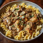 A close-up of Creamy Chicken Stroganoff with Mushrooms and Egg Noodles, garnished with fresh parsley.