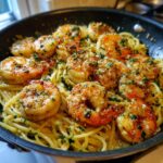 Close-up of Easy Baked Shrimp Scampi Pasta in a black skillet, topped with fresh parsley.