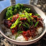 A close-up of a bowl of Easy Korean Gochujang Beef Bowls with rice, broccoli, and green onions.