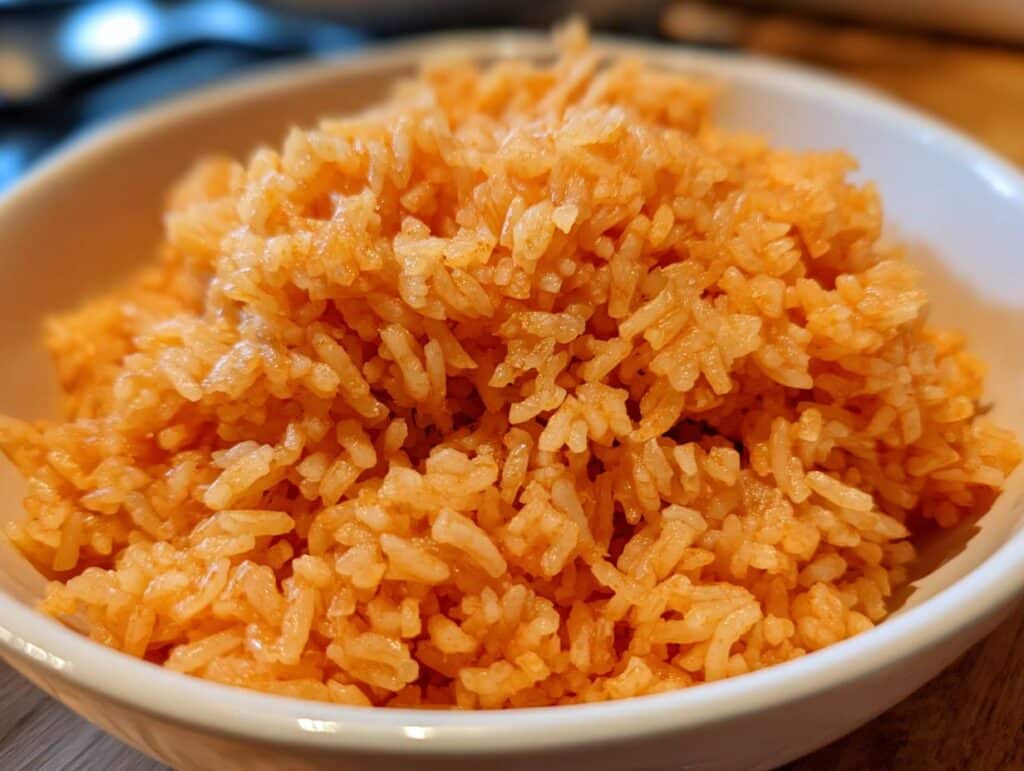 Close-up of a bowl filled with fluffy, vibrant orange Easy Restaurant Style Mexican Rice.