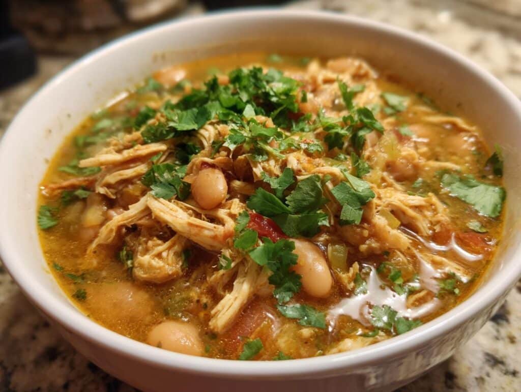 A close-up of a bowl of delicious white chicken chili, topped with fresh cilantro.