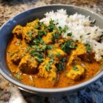 A bowl of delicious butter chicken instant pot with fluffy white rice and fresh cilantro garnish.