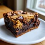 Close-up of a delicious brookies recipe slice, showcasing rich chocolate brownie base and chewy cookie topping with chocolate chips.