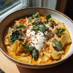 A bowl of creamy Easy Lasagna Soup Recipe topped with dollops of ricotta, fresh basil, and red pepper flakes.