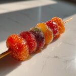 Close-up of a skewer with colorful fruits coated in sugar, showcasing an Easy Tanghulu Recipe.