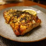 Close-up of a perfectly cooked Air Fryer Salmon fillet, garnished with rosemary and a lemon wedge.