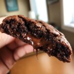 Close-up of a lava cookie broken in half, revealing a molten chocolate center.