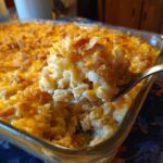 A spoonful of creamy tuna casserole with macaroni, cheese, and a crunchy topping.