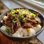 A flavorful hot honey beef bowl with rice, tender beef, sesame seeds, and green onions.