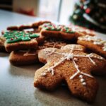 Close-up of decorated gingerbread cookies, including a gingerbread man with white icing and Christmas trees with green icing.