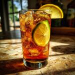 Refreshing pickle juice cola in a glass with ice, garnished with lemon and lime slices.