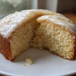 A slice of iced Rat cake on a white plate, showcasing the cake's texture and glaze.