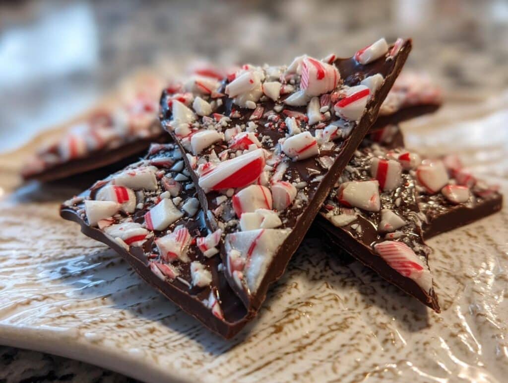 Close-up of delicious Candy Cane Chocolate Bark pieces on a decorative plate, perfect for gifting.