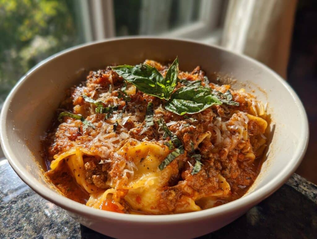 Close-up of a bowl of Lasagna Soup, topped with fresh basil and parmesan cheese.