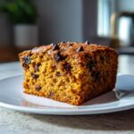 A slice of chocolate chip cake, perfect as a new years eve dessert, served on a white plate.