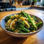 A close-up of a bowl of Garlic Olive Oil Broccoli Chickpea Pasta, featuring green broccoli florets, chickpeas, and pasta.