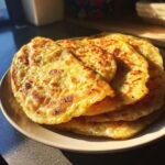 A close-up of a stack of golden-brown 5 ingredient gluten free flatbread on a plate, with crispy edges.