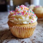 Close-up of a Baby in Bloom cupcake with white frosting and colorful sprinkles, perfect for a baby shower.