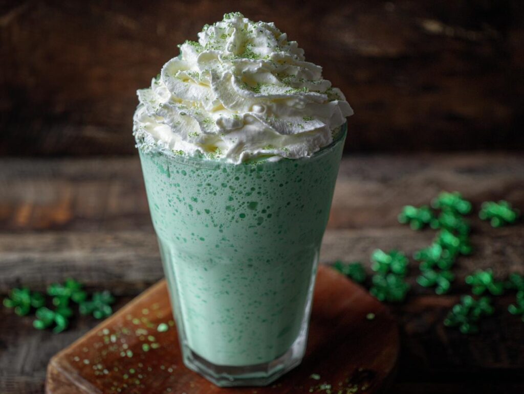 A creamy homemade shamrock shake topped with whipped cream and green sprinkles, ready to enjoy.