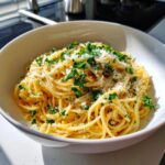 A bowl of Lemon Capellini Salad, topped with fresh parsley and grated cheese.