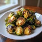 A plate piled high with delicious Roasted Brussels Sprouts, caramelized to perfection.