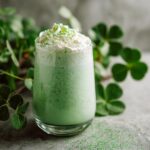A delicious homemade shamrock shake in a glass, topped with whipped cream and green sprinkles.