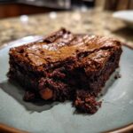 A single slice of fudgy sourdough discard brownies on a plate, showcasing its rich chocolate texture.