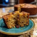 A slice of applesauce cake recipe easy apple sauce with raisins on a blue plate, showcasing its moist texture.