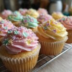 Close-up of easy spring flower cupcakes with pastel frosting and tiny flower decorations on a wire rack.