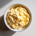 Bowl of creamy, yellow homemade mayonnaise from hard boiled eggs, top-down view.