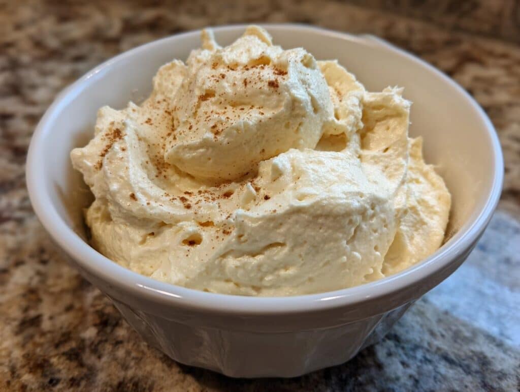 Creamy homemade mayonnaise from hard boiled eggs in a white bowl, sprinkled with spices.