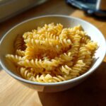 Bowl of pasta salad coated in a bright lemon vinegarette dressing.