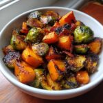 Bowl of spicy maple roasted butternut squash & brussels sprouts with crispy bacon.