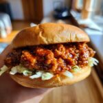Close-up of a 30 minute healthy turkey sloppy joe with homemade sauce, featuring shredded lettuce and a glossy bun.