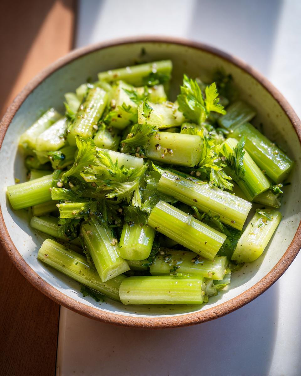 Close-up of a bowl filled with 15-Minute Crisp Celery Salad, showing the celery stalks and fresh herbs.