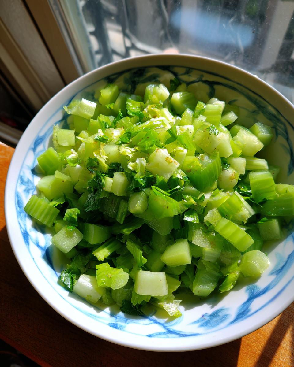 Diced celery in a bowl, ready for a 15-Minute Crisp Celery Salad. Fresh and green ingredients.