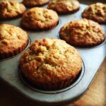 Close-up of freshly baked One-Bowl Banana Oatmeal Muffins in a muffin tin, golden brown and delicious.