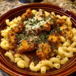 A bowl of Bww Garlic Parmesan Chicken Pasta, topped with parmesan and herbs.