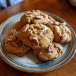 A plate of delicious Chewy Brown Butter Pecan Cookies, golden brown and topped with pecan pieces.