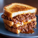 Stacked Copycat Big Mac Sloppy Joes sandwich on toasted bread, overflowing with savory meat filling.