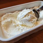 Scoop of Cottage Cheese Ice Cream Healthy Frozen Treat in a white dish with an ice cream scoop.