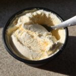 A container of creamy Cottage Cheese Ice Cream Healthy Frozen Treat with a spoon scooping out a serving.