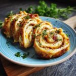 Close-up of 48 Easy Cream Cheese Taco Pinwheels sliced on a blue plate, garnished with fresh parsley.