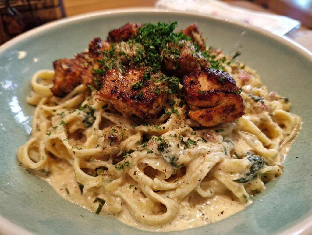 Close-up of 40-Minute Creamy Cajun Chicken Pasta featuring fettuccine, creamy sauce, Cajun chicken, and fresh herbs.