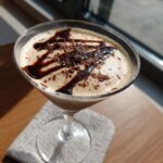 A delicious Easy 3-Ingredient Creamy Chocolate Martini in a glass, drizzled with chocolate sauce and shavings.