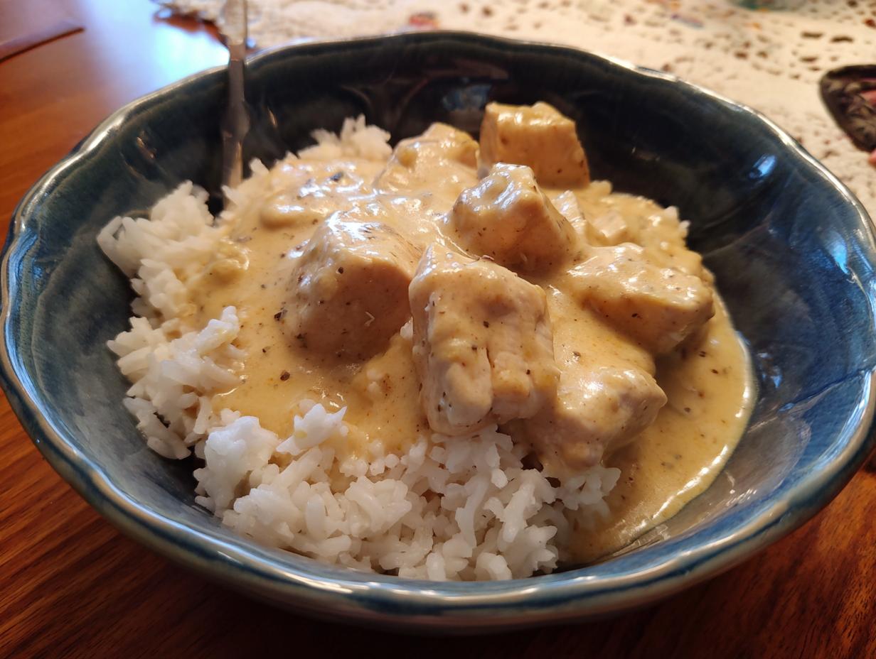 A bowl of Creamy Crockpot Chicken and Rice, featuring tender chicken pieces in a creamy sauce over white rice.