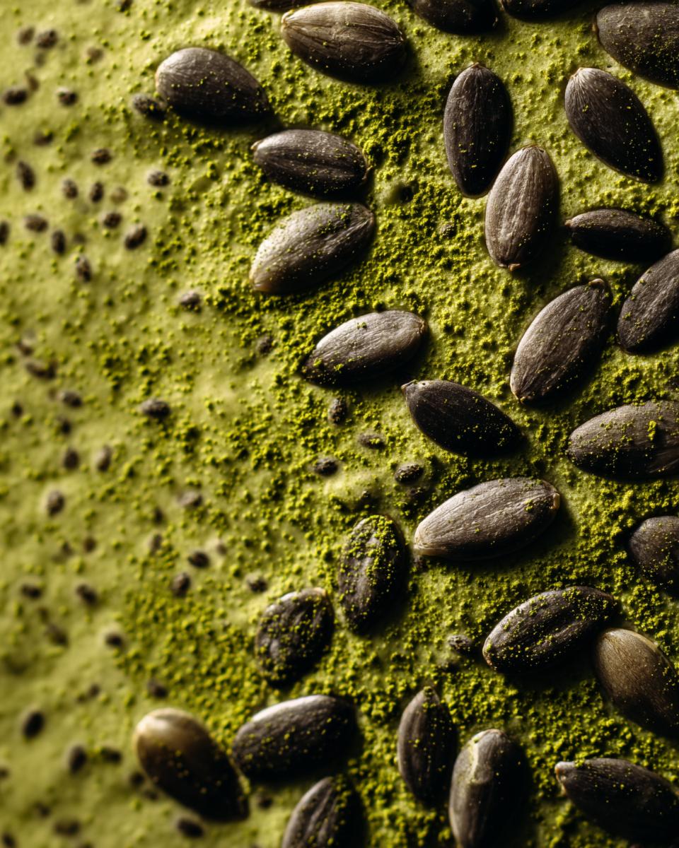 Close-up of Creamy Vegan Matcha Chia Pudding with sunflower seeds and matcha powder topping.