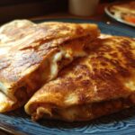 Two Crispy Air Fryer Chicken Mozzarella Wraps on a blue plate, showcasing the crunchy exterior and melted cheese inside.