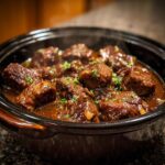 Close-up of Melt-in-Your-Mouth Crockpot Beef Tips in a slow cooker, garnished with parsley.