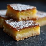 Close-up of Grandma's Lemon Bars topped with powdered sugar, showcasing the crust and lemon filling.